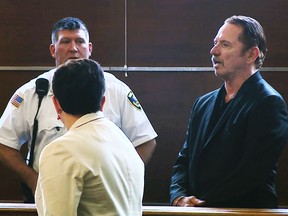 In this still image taken from video, actor Tom Wopat, right, stands during arraignment Thursday, Aug. 3, 2017, in Waltham, Mass., on indecent assault and battery and drug possession charges. Wopat who played Luke Duke on the 1980s television show "The Dukes of Hazzard" pleaded not guilty to the charges. Wopat, 65, was arrested on Wednesday night as he was leaving rehearsal for a performance of "42nd Street." (WCVB-TV via AP, Pool)