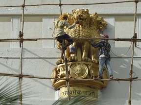 Indian workers paint a statue of the national emblem, a depiction of the Sarnath Lion Capital of Ashoka, ahead of the forthcoming Independence day celebrations at the state secretariat building in Mumbai on Aug. 7, 2017. (INDRANIL MUKHERJEE/AFP/Getty Images)