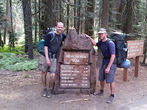 In this July 23, 2017, photo provided by Brian McKinney, Sam Vonderheide, right, and McKinney pose for a photo on the High Sierra trail in Sequoia National Park, Calif. The two hikers walking a High Sierra trail videotaped a nerve-wracking stare-down with a wild mountain lion. The video shows the adult lion scurry down a winding trail out of sight; moments later the hikers round a turn to see the large cat peering down on them from a rocky perch feet away. Wildlife biologist Daniel Gammons said the men did the right thing by staying calm. Biologists say you should make yourself appear big by waving your arms overhead and scare off the animal, as the men did. (Brian McKinney via AP)