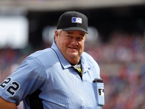 In this June 17, 2017 file photo, Crew chief Joe West smiles as he talks to staff in the Seattle Mariners dugout in the fourth inning of a baseball game against the Texas Rangers in Arlington, Texas. (AP Photo/Tony Gutierrez, File)