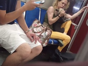 A woman grabs a dog in a screengrab from a video posted to YouTube in a handout photo. Authorities in Toronto have seized a dog that police say was seen in an online video being hit by its owner on a subway train.The Ontario Society for the Prevention of Cruelty to Animals took the dog after executing a search warrant on Monday and charges are pending against the owner, OSPCA spokeswoman Alison Cross said Tuesday. THE CANADIAN PRESS/HO-YouTube-Roxy Huang