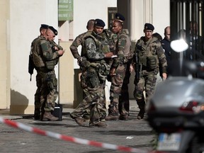 French soldiers gather at the site where a car slammed into soldiers on patrol in Levallois-Perret, outside Paris, on August 9, 2017.