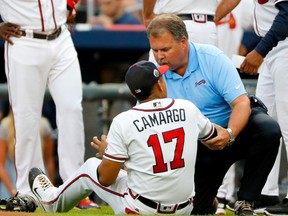 Atlanta Braves trainer Jim Lovell attends to Johan Camargo after he fell running onto the field to face the Philadelphia Phillies at SunTrust Park on August 8, 2017 in Atlanta. (Kevin C. Cox/Getty Images)