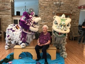 Spectator Joyce Snow sits with two lions at Good Samaritan Society Pembina Village in Evansburg on Saturday, July 29 (Photo Submitted).