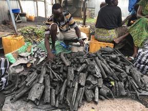 In this photo taken Thursday, June 29, 2017, Taban Ceasor sells bags of charcoal at his shop in Gudele Market, in Juba, South Sudan. The world’s youngest nation is well into its fourth year of civil war and as it is ravaged by fighting and hunger it also grapples with the devastating effects of climate change, which is exacerbated by the deforestation. (AP Photo/Sam Mednick)
