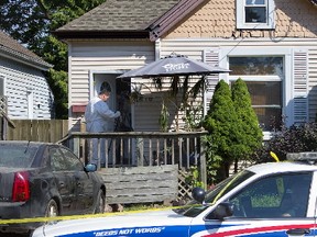 A member of the police forensics division collects evidence at 1070 Frances St. in London. A woman suffered life threatening injuries from an assault on Monday night. (DEREK RUTTAN, The London Free Press)