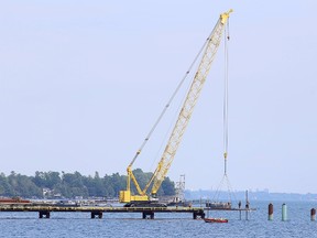 Workers assemble a dock near Millhaven that will serve as the mainland jumping off point for materials heading for Amherst Island for Algonquin Power's wind energy project near Millhaven, Ont. on Wednesday, Aug. 9, 2017. Elliot Ferguson/The Whig-Standard/Postmedia Network