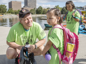 Ottawa police Sgt. Chris Hrnchiar, left, chats with four-year-old Napachie Pootoogook, centre, while Ellie, 8, look on at Dow's Lake during the 17th Flotilla for Friendship on Wednesday.