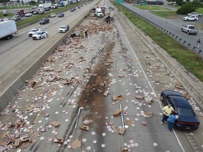 This Aug. 9, 2017 photo provided by the Arkansas Department of Transportation shows Arkansas highway Interstate 30, a cross-country route that was shut down in both directions for a time Wednesday, after an 18-wheeler was sliced open during an accident and spilled frozen pizzas across the road south of Little Rock, Ark. The interstate, was closed for several hours while crews cleaned up the mess. (Rusty Hubbard, Arkansas Department of Transportation via AP)