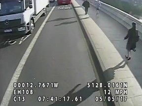 In this image taken from surveillance camera video released by London's Metropolitan Police on Tuesday, Aug. 8, 2017 shows a male jogger top right running towards a woman, bottom right, on Putney Bridge in London on May 5 before knocking her towards oncoming traffic. (Metropolitan Police via AP)