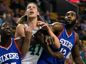 Philadelphia 76ers guard Elliot Williams, left, and forward Luc Richard Mbah a Moute, right, block out Boston Celtics centre Kelly Olynyk in Boston, Monday, Oct. 6, 2014. (AP Photo/Charles Krupa)