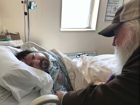 In this April 18, 2017, photo, Walter Wenger visits his severely disabled son, Steven, in a hospital in Kingston, N.Y., where he was moved after maggots were twice found in the area around his breathing tube while living in a state group home. The Associated Press obtained a confidential report on the state investigation that determined the 2016 infestations at the group home in Rome, N.Y., were the result of neglect by caregivers. In most states, details of abuse and neglect investigations in state-regulated institutions for the disabled are almost never made public. (AP Photo/David Klepper)