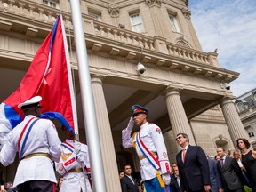 A Cuban honour guard prepares the Cuban flag for Cuban Foreign Minister Bruno Rodriguez (center right) before he raises the Cuban flag over their new embassy in Washington on July 20, 2015. (Andrew Harnik/AP Photo/Pool/Files)