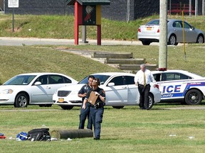 Suffolk County police work on the athletic field at Sachem High School East in Farmingville, N.Y., where a teenage football player was fatally injured during a drill earlier in morning, Thursday, Aug. 10, 2017. (James Carbone/Newsday via AP)