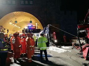 In this photo released by China's Xinhua News Agency, first responders work at the site of an accident after a bus hit the wall of the Qinling Mountains No. 1 Tunnel on the Jingkun Expressway in Ningshan County, northwestern China's Shaanxi Province, Friday, Aug. 11, 2017. (Xinhua via AP)
