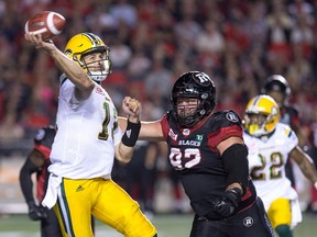 Edmonton QB Mike Reilly is forced to throw away the football by Ottawa's Zack Evans in the second quarter as the Ottawa Redblacks take on the Edmonton Eskimos in CFL action at TD Place in Ottawa on Thursday evening.