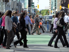 Pedestrians cross Laurier Avenue's bike lanes in Ottawa on a Thursday in May 2014.