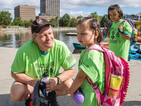 Ottawa Police Sgt. Chris Hrnchiar, left, chats with four-year-old Napatchie Pootoogook, centre, while Ellie, 8, looks on at Dow's Lake on Wednesday.