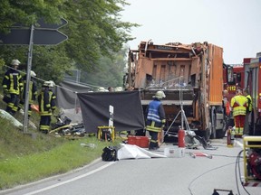 Firefighters work at the accident site where a garbage truck tipped over onto a car near Nagold, Germany, on Friday, Aug. 11, 2017. German news agency dpa reports that five people have been killed in the accident according to police in Baden-Wuerttemberg state. (Andreas Rosar/dpa via AP)