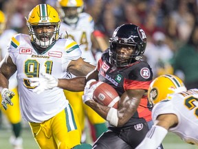 Edmonton Eskimos defensive lineman Marcus Howard, left, and defensive back Mercy Maston, right, move in on Ottawa Redblacks returner Quincy McDuffie during CFL action at Ottawa's TD Place in Ottawa on Aug. 10, 2017.