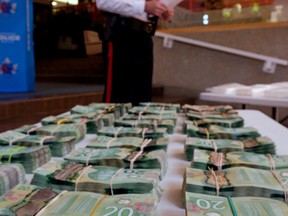 Inspector Jonathan Coughlan (Edmonton Police Service) displays the cash and drugs at police headquarters on August 11, 2017 that were seized from three men who were charged with drug trafficking. (PHOTO BY LARRY WONG/POSTMEDIA)