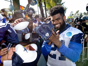 Dallas Cowboys running back Ezekiel Elliott signs autographs at the end of the day at NFL football training camp in Oxnard, Calif., on July 25, 2017. (AP Photo/Gus Ruelas)