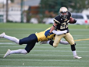 Edmonton Huskies Brandt Burzuk #22 is tackled by Edmonton Wildcats Jayden Dalke  #21 during the Prairie Football Conference junior football game at Clarke Stadium, September 17, 2016.