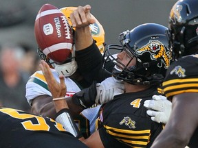 Hamilton Tiger-Cats quarterback Zach Collaros is hit by Edmonton Eskimos defensive lineman Euclid Cummings and fumbles during CFL action in Hamilton on July 20, 2017. (THE CANADIAN PRESS/Dave Chidley)