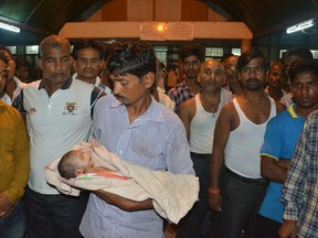 In this Friday, Aug. 11, 2017 photo, a man holds the lifeless body of his child outside Baba Raghav Das Medical College Hospital in Gorakhpur, in the northern Indian state of Uttar Pradesh. Parents of at least 35 children who have died in the hospital over the past three days have alleged that the fatalities were due to the lack of oxygen supply in the children's ward. District Magistrate Rajiv Rautela said Saturday the deaths of the children being treated for different ailments were due to natural causes. He denied that the lack of oxygen led to their deaths. (AP Photo)