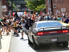A vehicle drives into a group of protesters demonstrating against a white nationalist rally in Charlottesville, Va., Saturday, Aug. 12, 2017. The nationalists were holding the rally to protest plans by the city of Charlottesville to remove a statue of Confederate Gen. Robert E. Lee. There were several hundred protesters marching in a long line when the car drove into a group of them. /The Daily Progress via AP)