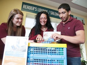 Giving the Basics organizers Sarah Lemieux, left, and Imran Bagha, along with Danielle Bray, drop-in co-ordinator at the Corner Clinic, sort through some of the donated items at the main branch of the Sudbury Public Library on Thursday. (Gino Donato/Sudbury Star)