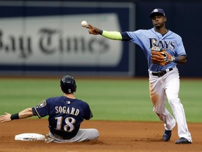 Tampa Bay Rays shortstop Adeiny Hechavarria forces Milwaukee Brewers' Eric Sogard (18) at second base and turns a double play on Travis Shaw during the eighth inning Aug. 6, 2017, in St. Petersburg, Fla. (CHRIS O'MEARA/AP)