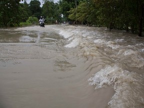 A motorbike drives through a flooded area in Murkata village east of Gauhati, India, Monday, Aug. 14, 2017. In the northeastern Indian state of Assam, the floodwaters have damaged bridges, downed power lines and washed away thousands of homes. Officials said at least 2.5 million people had been affected, including some 200,000 now staying in 440 relief camps. (AP Photo/Anupam Nath)