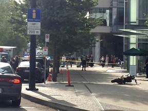 A motorcycle is on the ground in front of a shattered out glass window at the back of the Shaw tower. Cheryl Chan/Postmedia Network