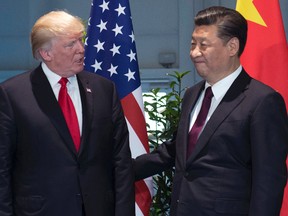 In this July 8, 2017, file photo, U.S. President Donald Trump, left, and China's President Xi Jinping arrive for a meeting on the sidelines of the G-20 Summit in Hamburg, Germany. Trump is planning to sign an executive action asking the U.S. Trade Representative to consider investigating China for the theft of U.S. technology and intellectual property. He is taking the step even as he seeks China’s help with the ongoing crisis with North Korea. (Saul Loeb/Pool Photo via AP, File)