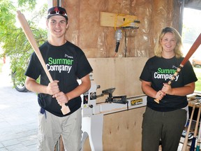 Judd Walker (left) holds a bat fresh off his lathe while Laura MacDougall, of Stratford Perth Centre for Business, is ready to swing a finished one. ANDY BADER/MITCHELL ADVOCATE