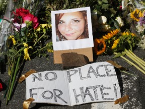 A makeshift memorial of flowers and a photo of victim, Heather Heyer, sits in Charlottesville, Va., Sunday, Aug. 13, 2017. (AP Photo/Steve Helber)