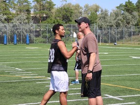 Arruda-Welch is seen re-acquainting himself with Blair Atikinson, who was promoted to offensive coordinator this past offseason. Atkinson was the receivers coach for 10 years prior. (Scott Billeck, Postmedia Network)