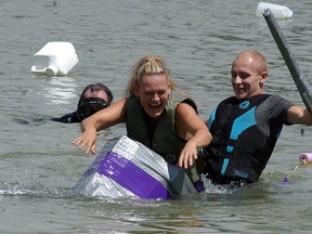 The mother-son team of Linnea Druer and Bailey Druer sink into the Sydenham River during the cardboard boat races during the 29th annual Wallaceburg Antique and Motor Boat Outing (WAMBO) on Saturday.