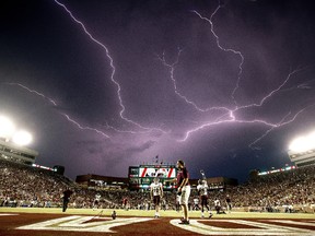 In this Sept. 5, 2015 file photo, a lightning strike occurs as Texas State warms up in Doak Campbell Stadium prior to an NCAA college football game against Florida State in Tallahassee, Fla. (AP Photo/Mark Wallheiser)