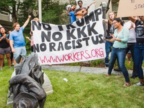 Protesters celebrate after toppling a statue of a Confederate solder in Durham, N.C. Monday, Aug. 14, 2017. Activists on Monday evening used a rope to pull down the monument outside a Durham courthouse. The Durham protest was in response to a white nationalist rally held in Charlottesville, Va., over the weekend. (Casey Toth/The Herald-Sun via AP)