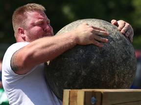 Tim Miller/The Intelligencer
Ben Ruckstuhl heaves a 410 lb. Atlas stone over a bar during the Quinte Ribfest Strongman Challenge in Trenton's Centennial Park on Saturday in Quinte West.