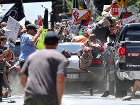 People fly into the air as a vehicle drives into a group of protesters demonstrating against a white nationalist rally in Charlottesville, Va., Saturday, Aug. 12, 2017. The nationalists were holding the rally to protest plans by the city of Charlottesville to remove a statue of Confederate Gen. Robert E. Lee. There were several hundred protesters marching in a long line when the car drove into a group of them. Ryan M. Kelly/The Daily Progress/Associated Press
