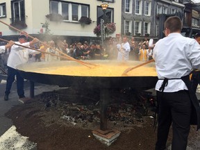 Cooks and volunteers stir eggs on an oversize pan at the 22nd Giant Omelet event in Malmedy, Belgium, Tuesday, Aug. 15, 2017. Defying rain and a tainted egg scandal that has shaken European consumers, a Belgian town has turned nearly 10,000 eggs into a giant omelet for the whole community. (AP Photo/Daniela Berretta)