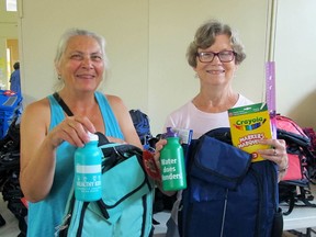 Members of the Social Issues Networking Group Tara Kainer, left, and Tanis Fairley posed with school supplies that will be handed out to students in need in the Back to School campaign on Wednesday. 2017. Megan Glover/The Kingston Whig-Standard