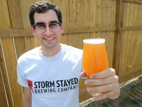 Justin Belanger hoists a glass of the Storm Stayed Brewing Company?s lager. (MORRIS LAMONT, The London Free Press)