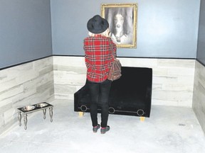 A visitor to Dog Tales takes a photo of original doggie art work in a stylish kennel. (Jim Fox/Special to Postmedia News)