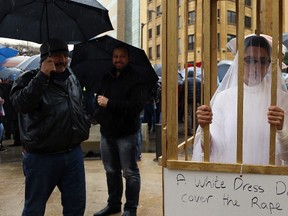 In this March 15, 2017 file photo, an activist from the Lebanese NGO Abaad stands in a cage dressed as a bride during a protest in front of the government building in downtown Beirut, Lebanon. (Hassan Ammar/AP Photo/Files)