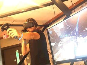 District Beta co-owner Travis Kelly demonstrates the virtual reality technology in one of the gaming booths which will be fully available after the site’s opening on Sept. 1. (Jeremiah Rodriguez/The Observer)