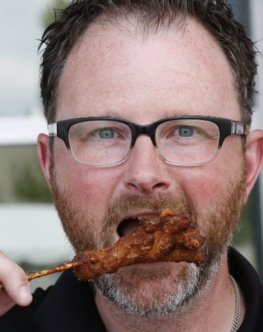 Scott Dennis of Coco's Concessions tries some deep fried chicken feet at the media preview for the 139th annual Canadian National Exhibition on Wednesday August 16, 2017. (Michael Peake/Toronto Sun)